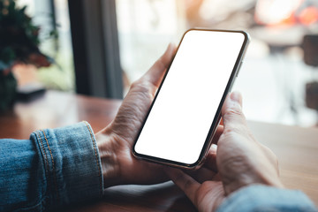 Mockup image blank white screen cell phone.woman hand holding texting using mobile on desk at coffee shop.background empty space for advertise text.people contact marketing business,technology