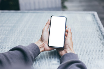 Mockup image blank white screen cell phone.woman hand holding texting using mobile on desk at coffee shop.background empty space for advertise text.people contact marketing business,technology