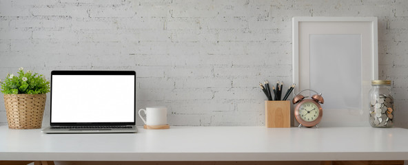 Cropped shot of simple workspace with mock-up laptop, stationery, decorations and copy space