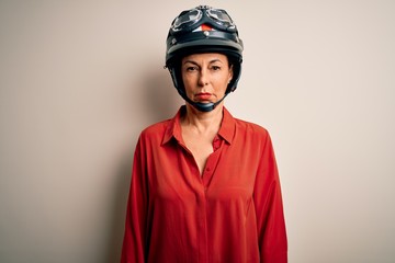 Middle age motorcyclist woman wearing motorcycle helmet over isolated white background depressed and worry for distress, crying angry and afraid. Sad expression.