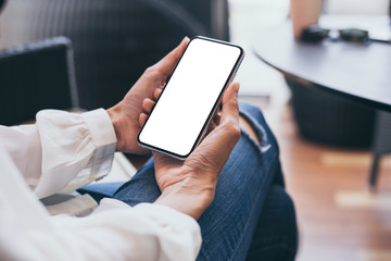 Mockup image blank white screen cell phone.woman hand holding texting using mobile on desk at coffee shop.background empty space for advertise text.people contact marketing business,technology