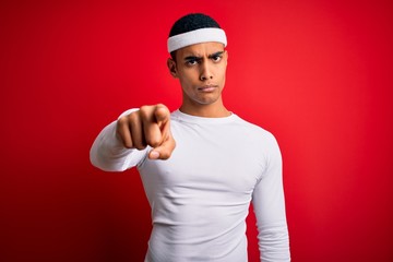 Fototapeta premium Young handsome african american sportsman wearing sportswear over red background pointing displeased and frustrated to the camera, angry and furious with you