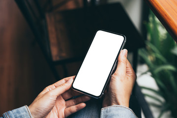 Mockup image blank white screen cell phone.woman hand holding texting using mobile on desk at coffee shop.background empty space for advertise text.people contact marketing business,technology