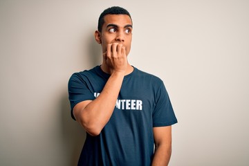 Young handsome african american man volunteering wearing t-shirt with volunteer message looking stressed and nervous with hands on mouth biting nails. Anxiety problem.