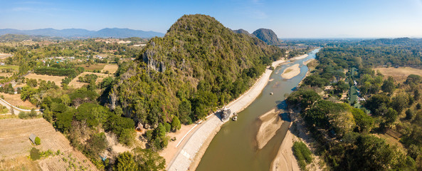 Aerial view of the mountain landscape with Kok river a river flowing out of the hills of Burma's Shan State winding its way across Chiang Rai province to Mekong river. Panorama view from drone.