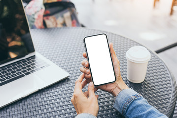 cell phone Mockup image blank white screen.woman hand holding texting using mobile on desk at coffee shop.background empty space for advertise text.people contact marketing business,technology