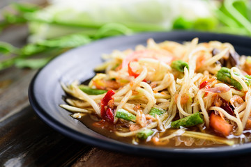 Thai food (Som Tum), spicy green papaya salad eating with fresh vegetables