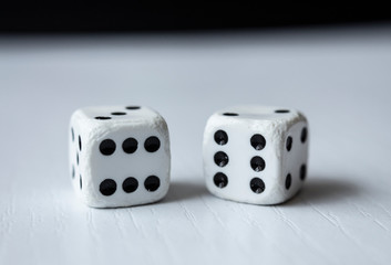 Macro photograhpy to an Old white dices with double six pair over a white table and black background