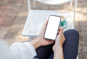 cell phone Mockup image blank white screen.woman hand holding texting using mobile on desk at coffee shop.background empty space for advertise text.people contact marketing business,technology