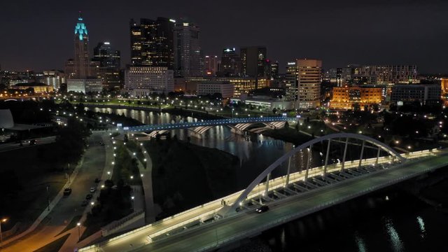 Aerial: Main Street Bridge crossing the Scioto River and downtown Columbus at night. Columbus. Ohio, USA. 