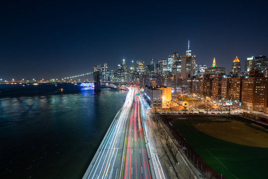 Image of New York City Skyline at Night with hudson river, urban skyscrapers, highway and bridge
