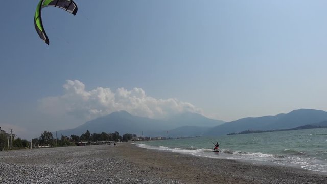 Fethiye, Turkey - 27th of Martch 2020: 4K Kitesurfer slides by along the beach
