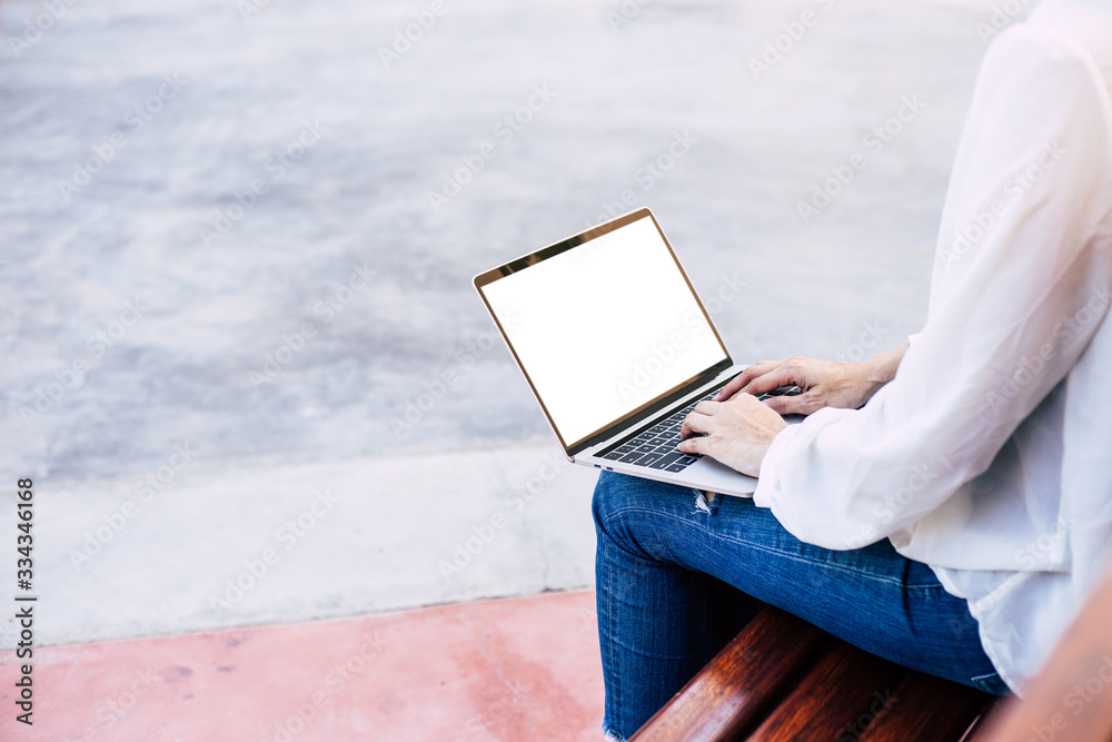 Wall mural computer mockup image blank screen with white background for advertising text,hand woman using lapto