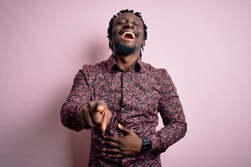 Young handsome african american man wearing casual shirt standing over pink background laughing at you, pointing finger to the camera with hand over body, shame expression