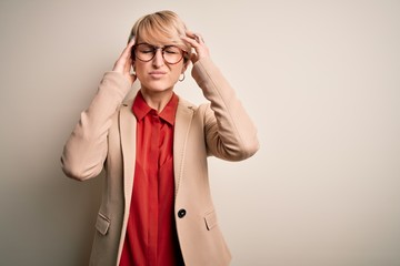 Young blonde business woman with short hair wearing glasses and elegant jacket suffering from headache desperate and stressed because pain and migraine. Hands on head.