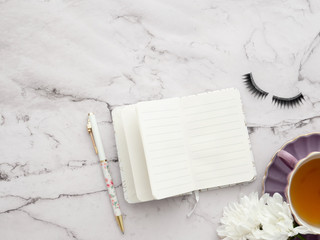 open notebook with blank pages and coffee cup on marble