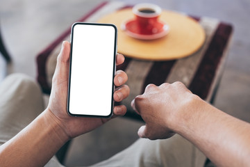 cell phone Mockup image blank white screen.man hand holding texting using mobile on desk at coffee shop.background empty space for advertise text.people contact marketing business,technology