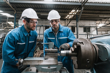 Fototapeta na wymiar Engineer men wearing uniform safety in factory working machine lathe metal.