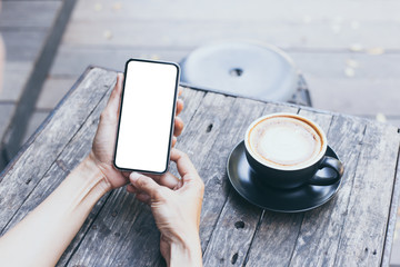 cell phone Mockup image blank white screen.woman hand holding texting using mobile on desk at coffee shop.background empty space for advertise text.people contact marketing business,technology