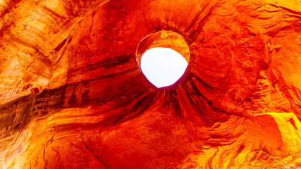 A hole in the ceiling of Big Hogan Arch, a large arch in Monument Valley Navajo Tribal Park on the Utah and Arizona border, USA. The weather stained shape on the ceiling is called the Dancing Ghost