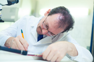 Naklejka premium Chemist crazy. A mad scientist conducts experiments in a scientific laboratory. Intently records the results of the study. COVID-19. COVID Coronavirus