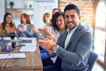 Group of business workers smiling happy and confident. Working together with smile on face looking at the camera applauding at the office