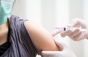 Obraz premium close up doctor's hand injecting for vaccination in the shoulder woman patient.Vaccine for protection HPV (Human Papillomavirus) infection.Vaccination for coronavirus treatment.