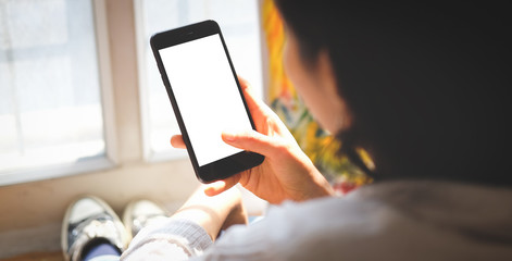 Cropped shot view of man hands holding smart phone with blank copy space screen for your text message or information content, female reading text message on cell telephone during in urban setting. 