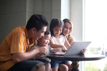 Asian family using computer on line for entertainment or social media