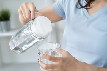 woman pouring mineral water to glass.