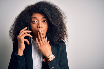 Fototapeta na wymiar Young african american business woman with afro hair calling using smartphone mobile cover mouth with hand shocked with shame for mistake, expression of fear, scared in silence, secret concept
