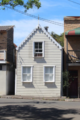 Facade of an old white two storey weather board house