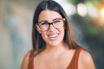 Young beautiful woman smiling happy and confident. Standing with smile on face at the town street