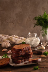 Black bread croutons with garlic and herbs with sauce on a wooden table