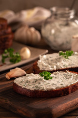Black bread croutons with garlic and herbs with sauce on a wooden table