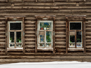 Fototapeta na wymiar Three windows of a wooden house