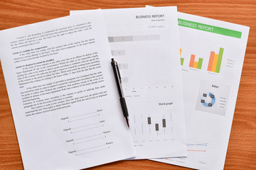 Top view of paper, graphs and charts about business placed on the table