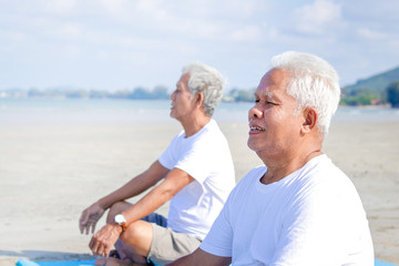 Two elderly men exercise At the beach by the sea in the morning Have a happy life after retirement. Concepts of older communities and health care