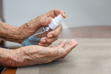 Elderly woman applying alcohol cleaning hands to helping protect from coronavirus covid-19