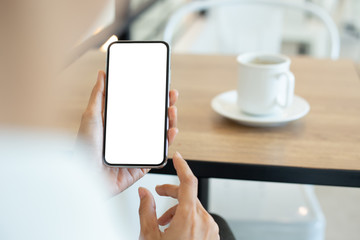 cell phone Mockup image blank white screen.woman hand holding texting using mobile on desk at coffee shop.background empty space for advertise text.people contact marketing business,technology