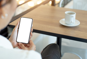 cell phone Mockup image blank white screen.woman hand holding texting using mobile on desk at coffee shop.background empty space for advertise text.people contact marketing business,technology