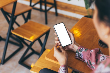 cell phone Mockup image blank white screen.woman hand holding texting using mobile on desk at coffee shop.background empty space for advertise text.people contact marketing business,technology