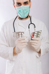 Doctor's hands in white gloves hold pills close-up. Types of drugs. Medical worker in a white coat