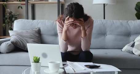 Stressed worried young woman feels panic about financial problem checking household payments. Frustrated female renter calculating bills, bank mortgage debt looking desperate about bankruptcy at home. - Powered by Adobe