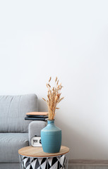 Interior of modern room with comfortable sofa and table with vase
