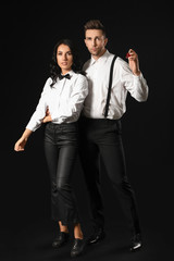 Stylish young couple with perfume on dark background