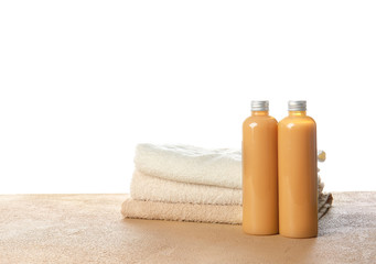 Obraz na płótnie Canvas Shampoo and towels on table against white background
