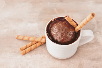 Chocolate mug cake on grey background