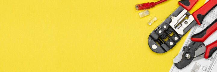 Crimping tools and wires with connectors on a yellow background. Tools for the Internet. Banner