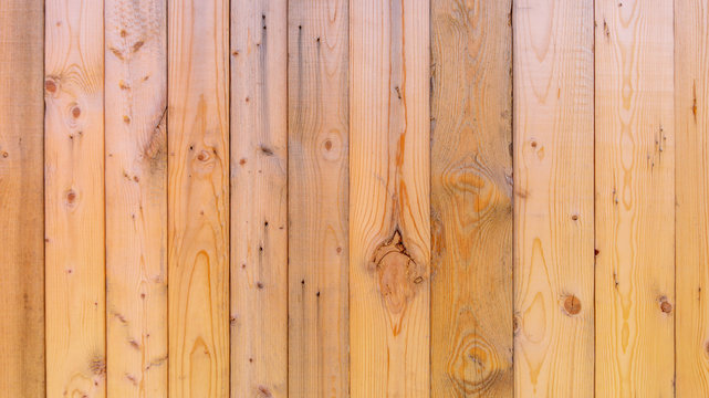 Plain fresh recycled wood background in panels, showing wood grain and nuts, with imperfections.  Copy space and slightly blurred background, with a rustic style. Wood has not been weathered.